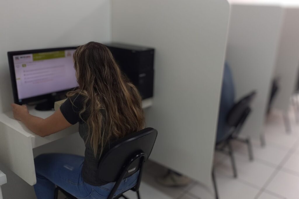 Mulher trabalhando em computador de escritório.