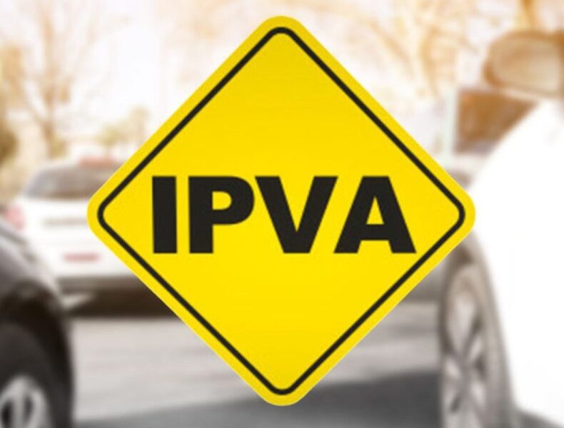 Placa amarela sinaliza IPVA com carro ao fundo.